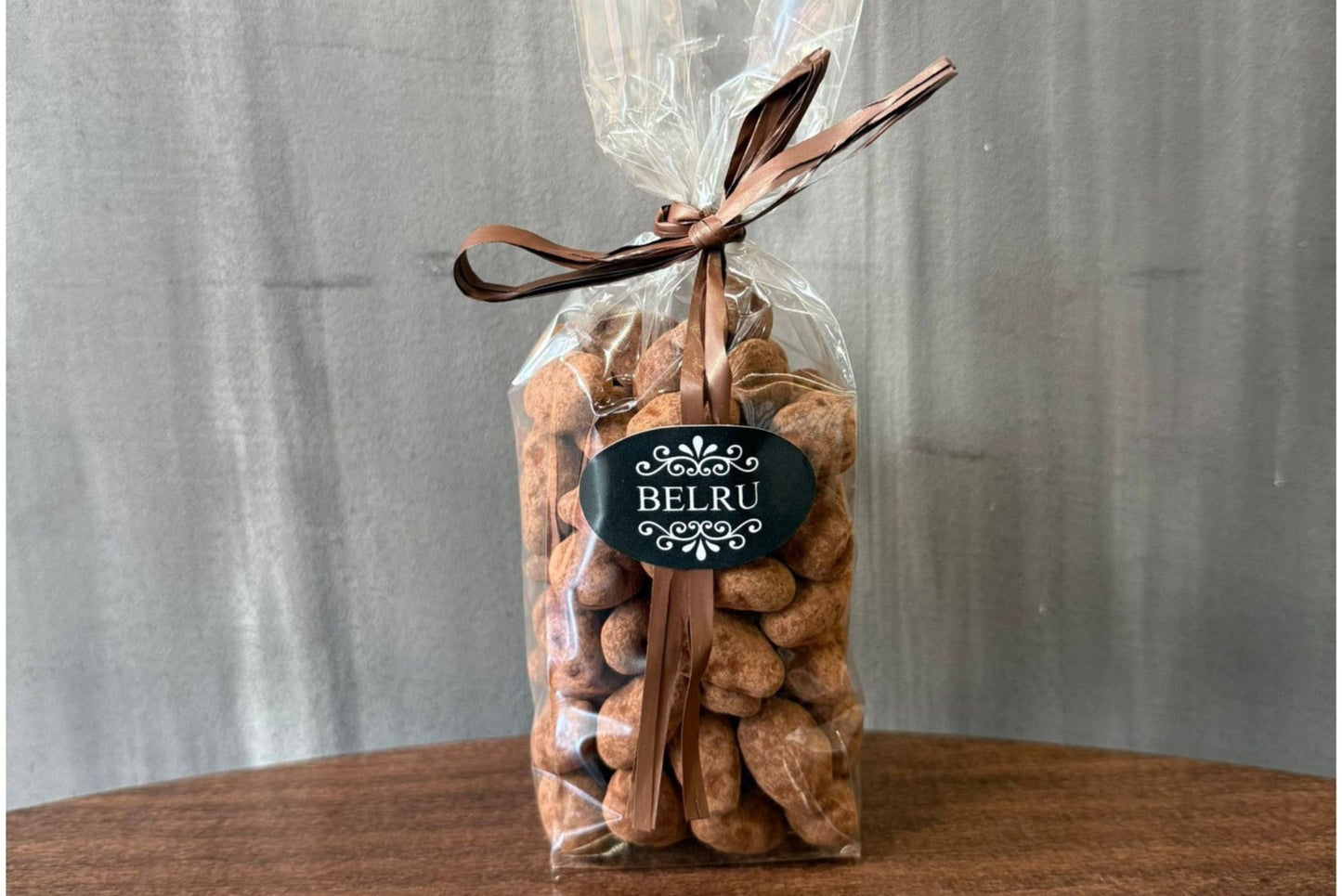 Bag of cookies with a visible brand label on a wooden surface and gray background